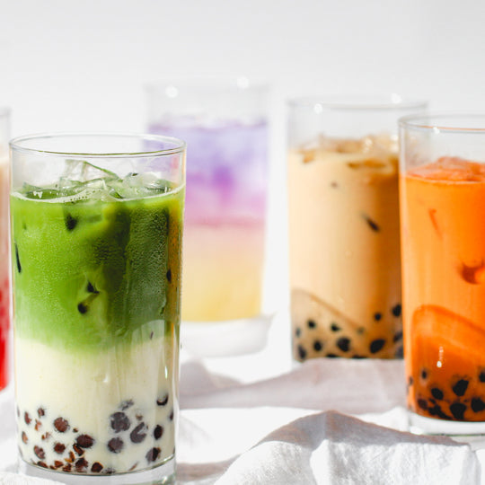 A collection of Cha Community boba tea beverages including Strawberries & Cream, Matcha Latte, Galaxy Lemonade, Milk Tea, Thai Tea, and Strawberry Matcha Latte